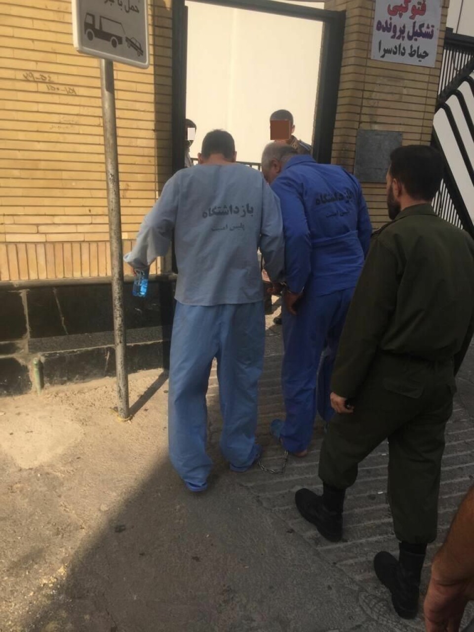 Til venstre i lyseblå fangedrakt går Sorab Abolfathi lenket til en annen fange i Iran. Foto: Privat