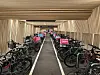 Sykler med rosa Foodora-bager står tett i en moderne, opplyst gangtunnel