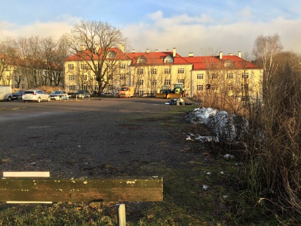 En tidligere fotballplass på Torshovtoppen som ble omgjort til parkeringsplass. I bakgrunnen eksisterende Torshov-bebyggelse som kan bli «overskygget» dersom tomten blir utbygd tett og kompakt med leiligheter, ifølge Frode Oldereid. Foto: Frode Oldereid