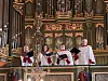 Oslo Domkor synger i hvite korkapper foran et stort orgel i kirkerommet i Oslo domkirke.