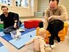 To fedre sitter på matter og leker med baby i åpen barnehage.