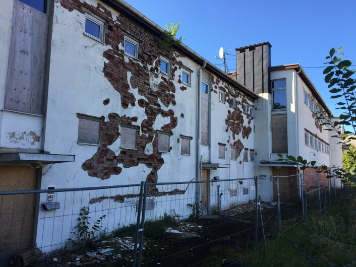 En fasade i svært dårlig forfatning. Unni Hestvedt er fornøyd med at første etasje er stengt igjen med sponplater. Foto: Vegard Velle En fasade i svært dårlig forfatning. Unni Hestvedt er fornøyd med at første etasje er stengt igjen med sponplater. Foto: Vegard Velle