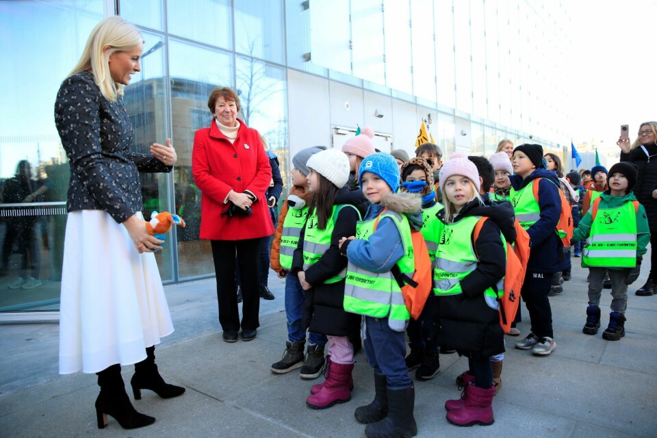 Skoleelevene bar bøkene i ryggsekker. Kronprinsesse Mette-Marit møtte barna nede ved inngangen til det nye biblioteket. Foto: Stian Lysberg Solum / NTB scanpix