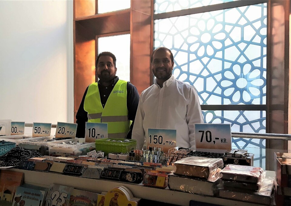 Daglig leder Ikhlaq Bhai i hvit skjorte sammen med Abdul Wahab Shukat viser frem den lille moskebutikken. Dessverre var de denne dagen utsolgt for islamofobi kurerende tyggegummi. Foto: Tarjei Kidd Olsen