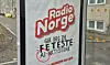 Noen har byttet ut en genuin Radio Norge-reklame på bussholdeplassen Helgesens gate med en falsk Radio Norge-reklame. Der ser det ut som om radiostasjoen skryter av å ha de feteste AI-artistene.