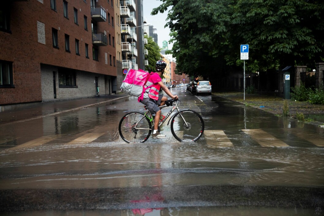 Et bud fra Foodora sykler gjennom vannmasser i Vahls gate i Oslo. Foto: Berit Roald / NTB scanpix