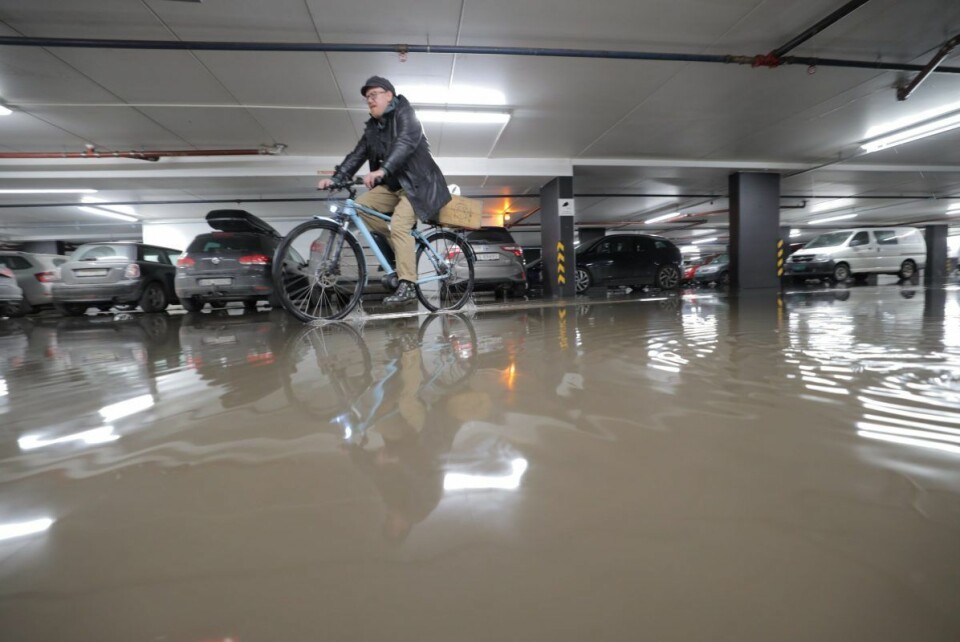 Denne syklisten tok seg elegant gjennom vannet i parkeringshuset i Kiellands hus mandag ettermiddag. Foto: Ørn E. Borgen / NTB scanpix