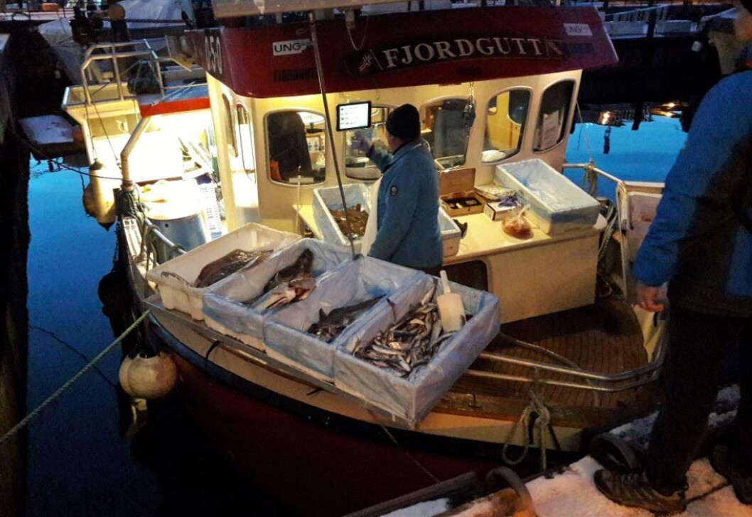 Tidlig om morgenen åpner salget på Rådhuskaia. Her betjener Christian Rochstad om bord i Fjordgutt køen av sjømatelskende kunder. Foto: Anders Høilund Tidlig om morgenen åpner salget på Rådhuskaia. Her betjener Christian Rochstad om bord i Fjordgutt køen av sjømatelskende kunder. Foto: Anders Høilund