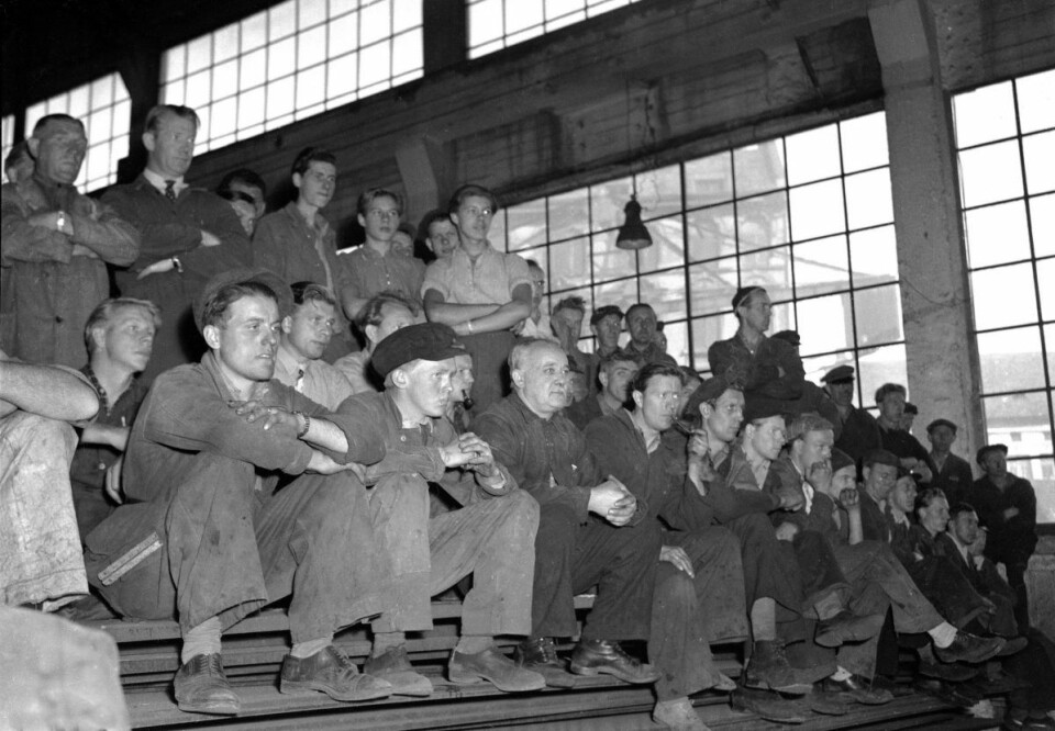 Arbeidere ved Akers Mekaniske verksted, det som i dag er Aker brygge, mens de i 1947 lytter til Filharmonien som spiller i en av verkstedhallene. Foto: NTB / Scanpix