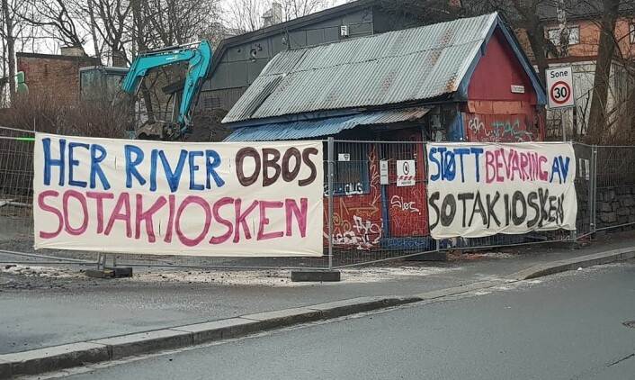Aksjonister har festet store bannere på sikkerhetsgjerdet rundt Sotakiosken. Foto: Hege Stensrud Høsøien