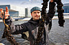 En person, daglig leder August Borge Harbo i Urban Ocean, viser fram tau og mørke blåskjellrester ved vannet, med Operaen i Oslo i bakgrunnen.