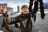 En person, daglig leder August Borge Harbo i Urban Ocean, viser fram tau og mørke blåskjellrester ved vannet, med Operaen i Oslo i bakgrunnen.