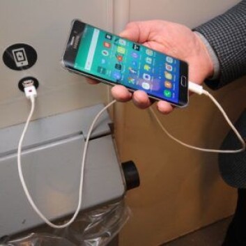 Lading av telefonen på t-banen. Se sort klistremerke og USB-uttak i veggen. Foto: Øystein Dahl Johansen/Ruter Lading av telefonen på t-banen. Se sort klistremerke og USB-uttak i veggen. Foto: Øystein Dahl Johansen/Ruter