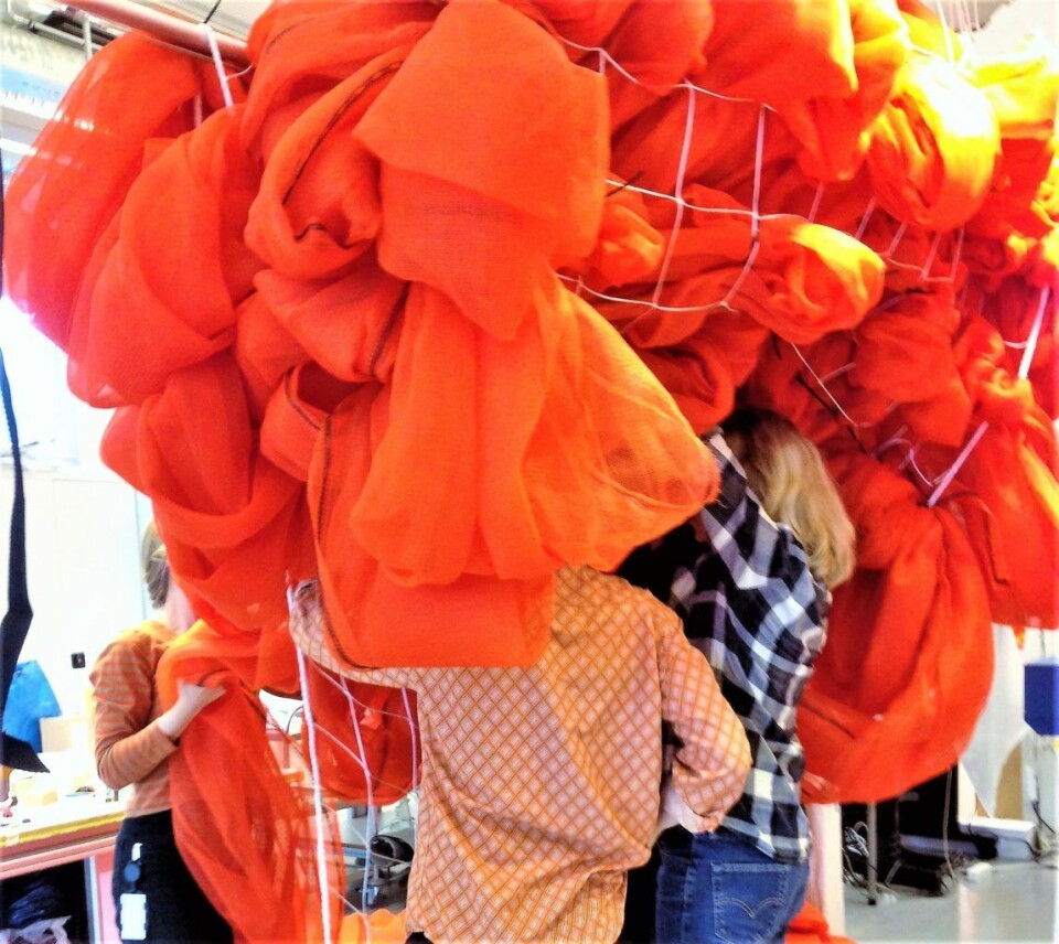 Kunstverket Soft Spot markerer Norske tekstilkunstneres 40-års-jubileum med en solid dæsj oransje på Flytogterminalens utvendige fasade på Oslo S. Foto: Kulturetaten