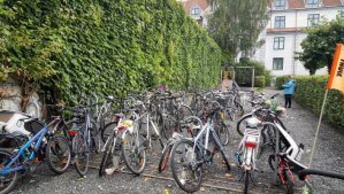 Denne stripen med sykkelparkering og lekeplass (bak), tilhørende sameiene ifølge Strøm og Håkonsen, har Merkantilbygg omgjort til grusvei i tegningene sine. Bygget til venstre er en av de to garasjene som utbygger vil bygge på og gjøre om til lavblokker. Foto: Tarjei Kidd Olsen Denne stripen med sykkelparkering og lekeplass (bak), tilhørende sameiene ifølge Strøm og Håkonsen, har Merkantilbygg omgjort til grusvei i tegningene sine. Bygget til venstre er en av de to garasjene som utbygger vil bygge på og gjøre om til lavblokker. Foto: Tarjei Kidd Olsen