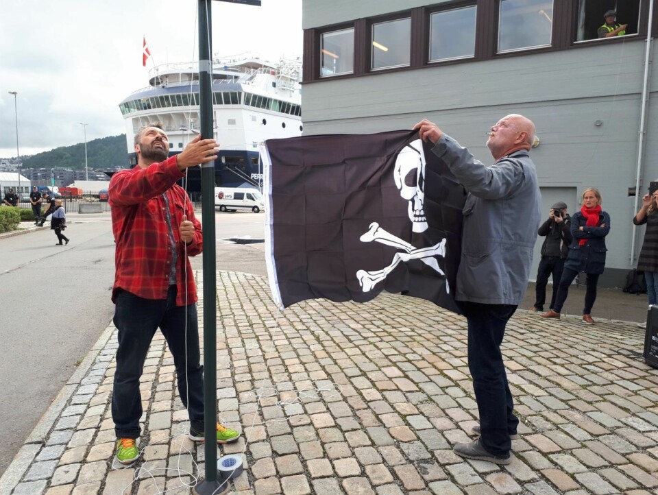 1. september heiste havnearbeider Rune Berre (t.v) og leder i Norsk Transportarbeiderforbund, Lars M. Johnsen, piratflagget over Oslo havn. Mandag ble det klart at havna blir  såkalt bekvemmelighetshavn. Foto: Christian Boger
