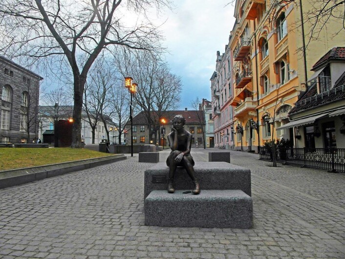 Sittende pike med hodetelefoner, av Marit Krogh. Statue på Bankplassen som hindrer fremkommeligheten på en trivelig måte. Foto: Cafe Engebret Sittende pike med hodetelefoner, av Marit Krogh. Statue på Bankplassen som hindrer fremkommeligheten på en trivelig måte. Foto: Cafe Engebret