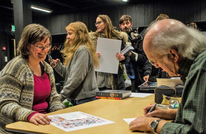 Don Rosa signerer og skriver en liten hilsen til Ingeborg Marie Ekenes, mens andre fans venter med på å få signert bøker og plakater. Foto: Morten Lauveng Jørgensen Don Rosa signerer og skriver en liten hilsen til Ingeborg Marie Ekenes, mens andre fans venter med på å få signert bøker og plakater. Foto: Morten Lauveng Jørgensen