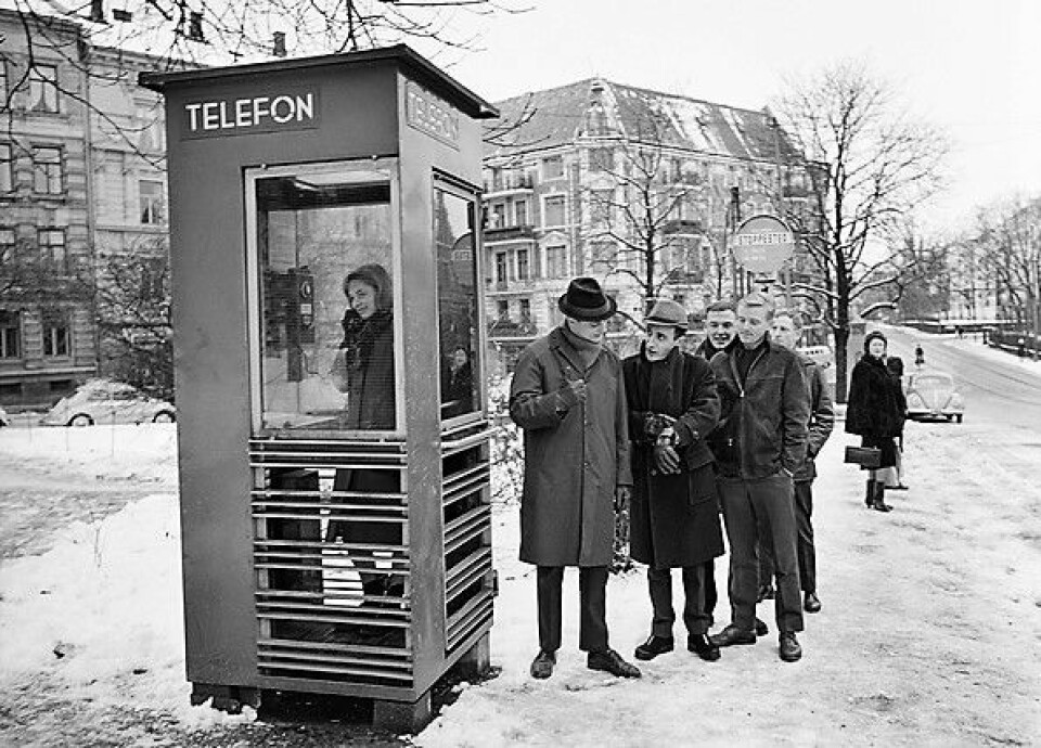 Johnny Bergh (med hatt), Nandor Hamza (viser klokken) og Stein Roger Bull (hendene i bukselommen), i omtrent 1965. Fotografert i forbindelse med fjernsynsproduksjonen 'Kunden har alltid rett'. Foto: HENRIK ØRSTED / OSLO MUSEUM / CC BY-SA