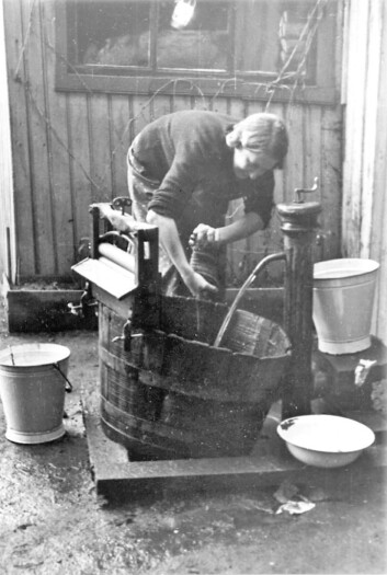 Kvinne vasker tøy utendørs, utstyrt med vannpost. Foto: Nanna Broch Kvinne vasker tøy utendørs, utstyrt med vannpost. Foto: Nanna Broch