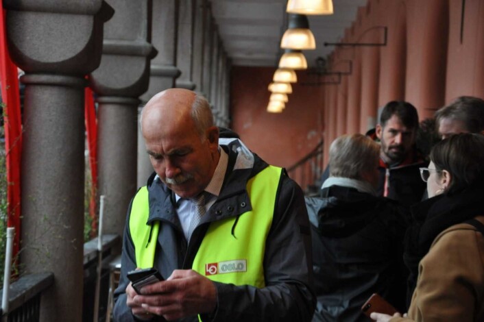 Mens hovedtalerne snakker til tusenvis fra talerstolen står togsjef Steinar Saghaug i balustraden ved Youngstorget og sjekker siste informasjon om 1.maitoget. Foto: Arnsten Linstad Mens hovedtalerne snakker til tusenvis fra talerstolen står togsjef Steinar Saghaug i balustraden ved Youngstorget og sjekker siste informasjon om 1.maitoget. Foto: Arnsten Linstad