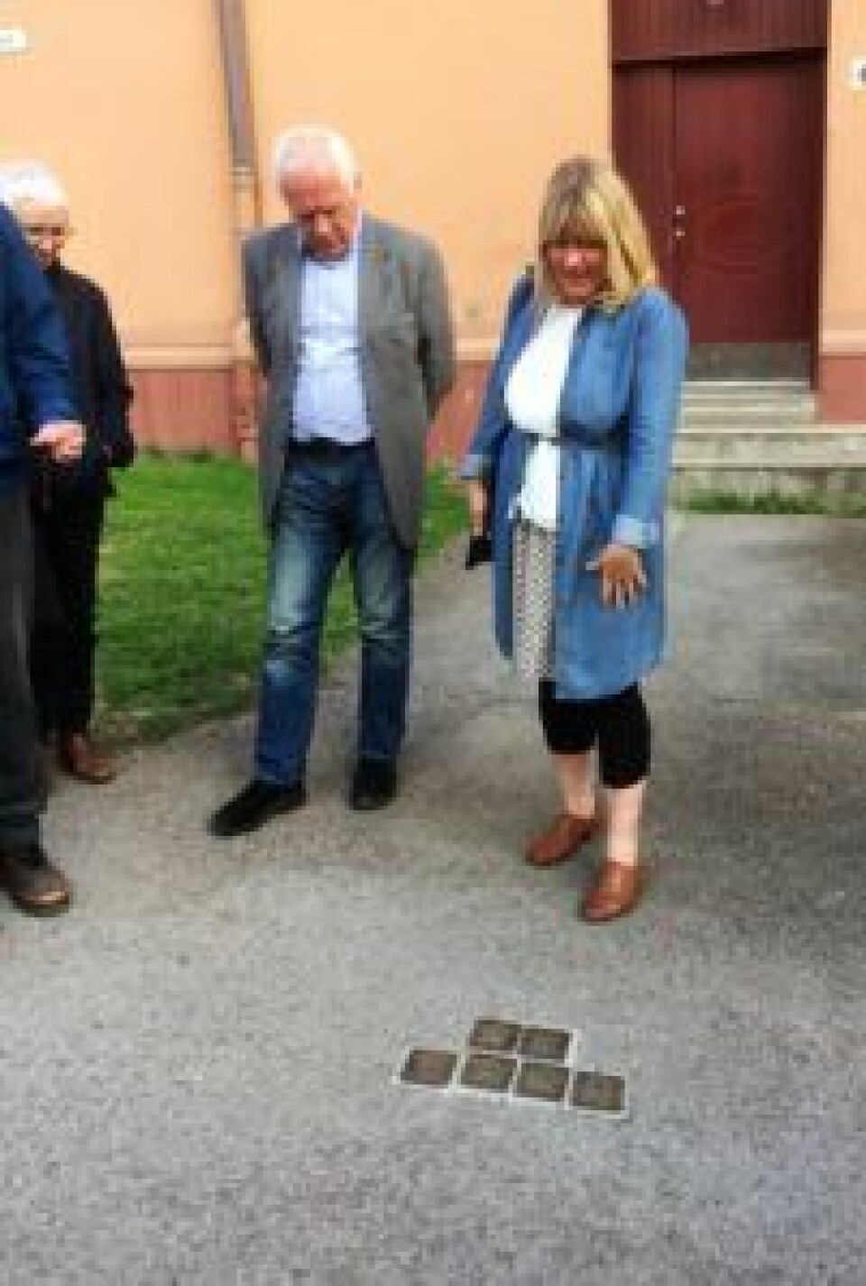 Historiker Gro Røde peker på snublesteinene banket inn i gaten for å minnes historien om jøder som ble deportert og drept i utrydningsleire under 2. verdenskrig. Foto: Kjersti Opstad