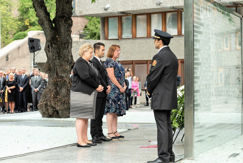 Fra venstre: statsminister Erna Solberg, AUF-leder Mani Hussaini og støttegruppens leder, Lisbeth Røyneland, legger ned krans ved det midlertidige minnesmerket. Foto: Ann Kristin Lindaas / KMD