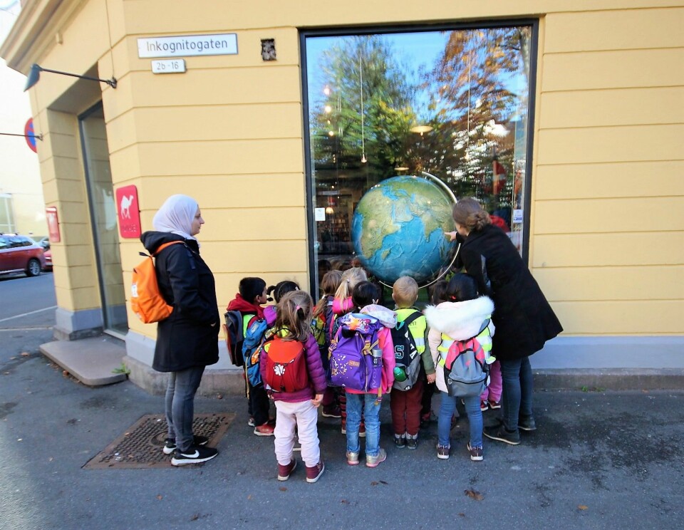 Ungene fra Uranienborg barnehage er bergtatt av Nomadens kjempeglobus. Om noen år sitter ungene selv i butikken og planlegger sine opplevelsesferier. Foto: André Kjernsli
