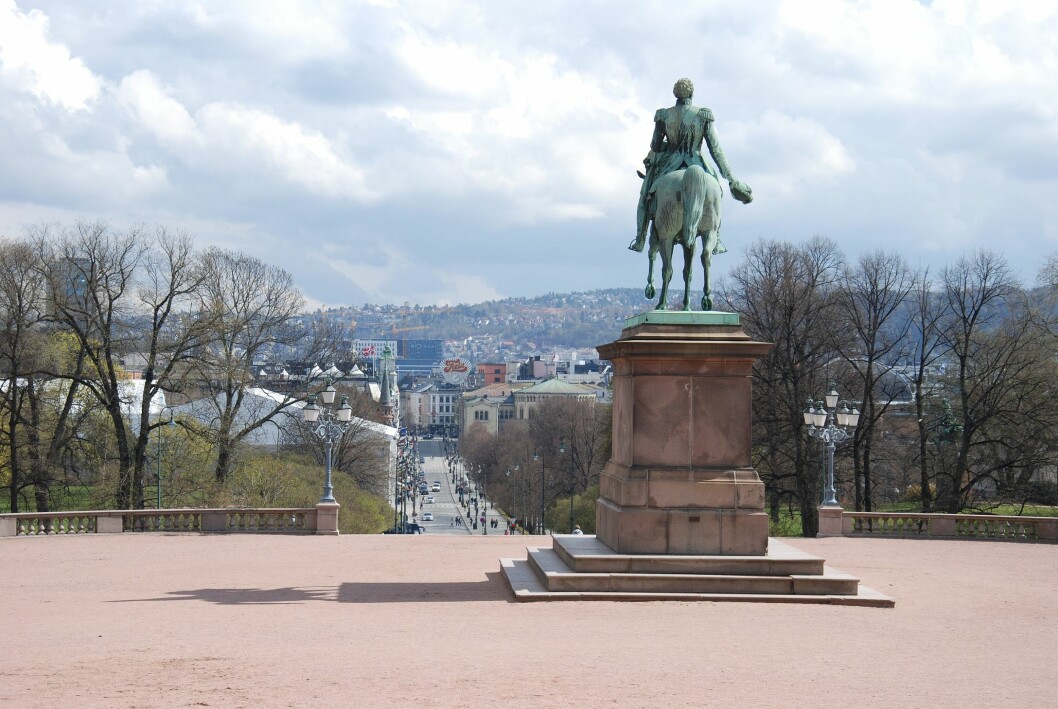 Kong Karl Johan skuer utover kongeriket Norge og Karl Johans gate fra Slottsplassen. På den ene sida av sokkelen står inskripsjonen «