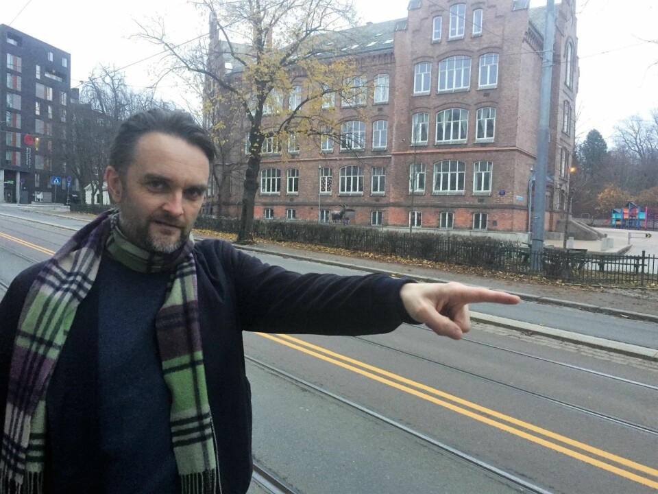 Pappa Stian Schjelderup peker ut skoleveien for barna til Laggegata skole, i bakgrunnen. Foto: Vegard Velle