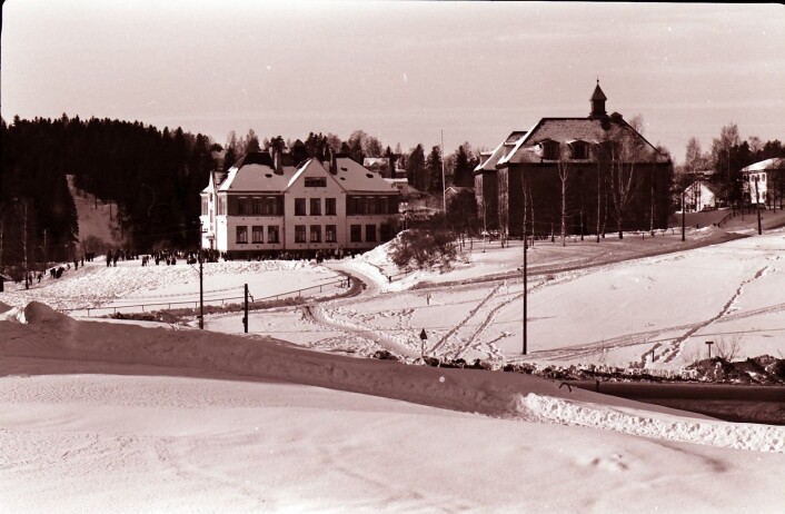 Østensjø skole med Rognerudbakken i lia i bakgrunnen i 1967. Helt til opp på 1970-tallet arrangerte skolen hopprenn i skoletiden. Fortsatt kan man se rester av Rognerudbakken i skogen på andre siden av Østensjøveien. Foto: Østensjø historielag. Østensjø skole med Rognerudbakken i lia i bakgrunnen i 1967. Helt til opp på 1970-tallet arrangerte skolen hopprenn i skoletiden. Fortsatt kan man se rester av Rognerudbakken i skogen på andre siden av Østensjøveien. Foto: Østensjø historielag.