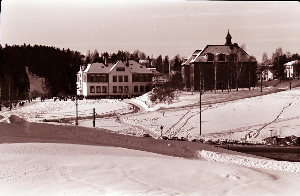 Østensjø skole med Rognerudbakken i lia i bakgrunnen i 1967. Helt til opp på 1970-tallet arrangerte skolen hopprenn i skoletiden. Fortsatt kan man se rester av Rognerudbakken i skogen på andre siden av Østensjøveien. Foto: Østensjø historielag.