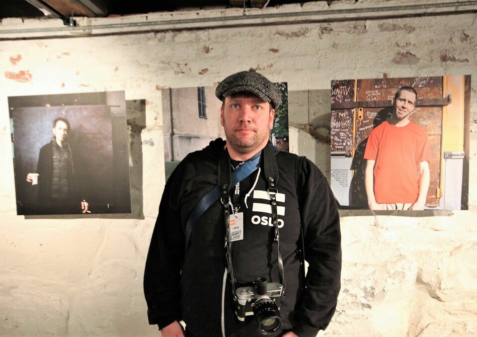 Niklas Mørkland foran noen av portrettene han har tatt av =Oslo-selgerne. Foto: André Kjernsli