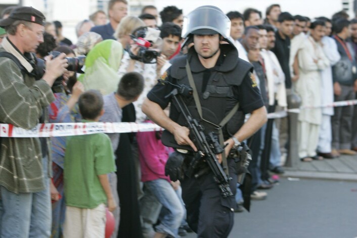 Bevæpnet politimann og skuelystne etter skyting og gjengoppgjør ved Aker brygge i august 2006.<br />Foto: Heiko Junge / SCANPIX Bevæpnet politimann og skuelystne etter skyting og gjengoppgjør ved Aker brygge i august 2006.<br />Foto: Heiko Junge / SCANPIX