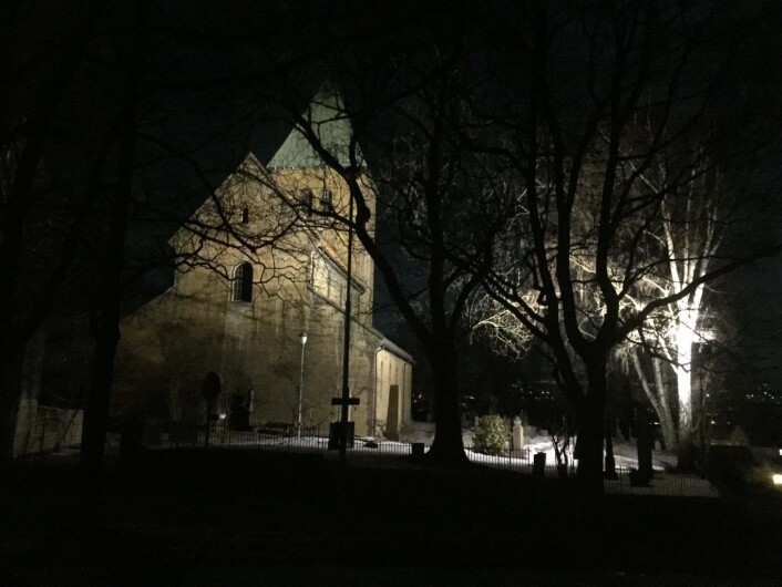 Jeg kikker opp på Gamle Aker kirke og tar farvel. Å få lov til å møte en kirke med en så mektig historie ved midnatt, i fullmånelys, har vært magisk, selv om jeg hverken så eller hørte dragen den vokter over. Foto: Kjersti Opstad Jeg kikker opp på Gamle Aker kirke og tar farvel. Å få lov til å møte en kirke med en så mektig historie ved midnatt, i fullmånelys, har vært magisk, selv om jeg hverken så eller hørte dragen den vokter over. Foto: Kjersti Opstad