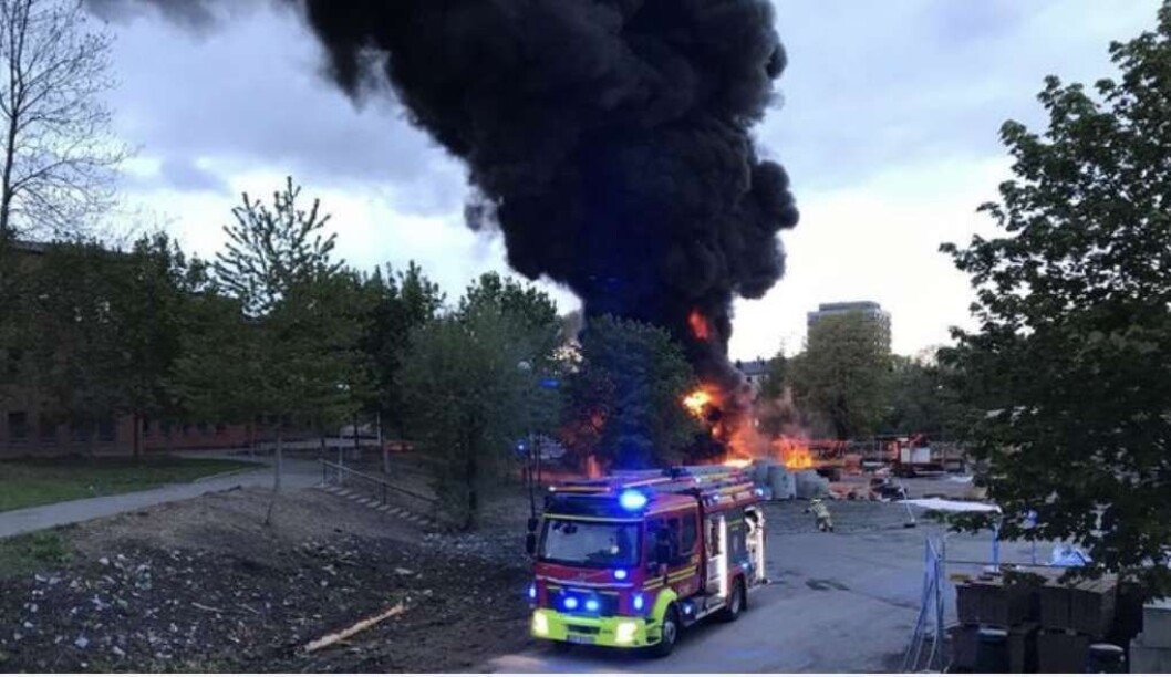 Svart røyk velter opp fra antente bygningsmaterialer ved Jordal Amfi. Folk i nabolaget bes lukke vinduer og dører. Foto: Stian Solberg Svart røyk velter opp fra antente bygningsmaterialer ved Jordal Amfi. Folk i nabolaget bes lukke vinduer og dører. Foto: Stian Solberg