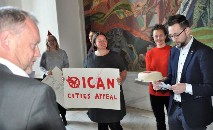 Representanter for nobelprisvinner ICAN, Nei til atomvåpen sammen med Norsk Folkehjelps generalsekretær Henriette Westhrin (holder ICAN-plakat) serverte byrådsleder Raymond Johansen marsipankake. Foto: Arnsten Linstad Representanter for nobelprisvinner ICAN, Nei til atomvåpen sammen med Norsk Folkehjelps generalsekretær Henriette Westhrin (holder ICAN-plakat) serverte byrådsleder Raymond Johansen marsipankake. Foto: Arnsten Linstad