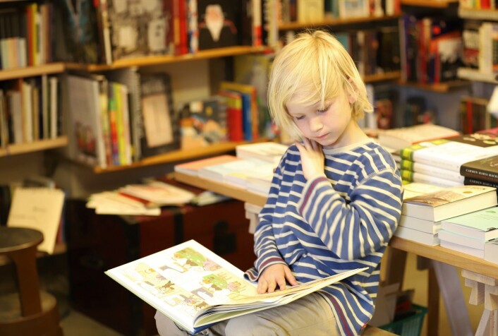 Lars Mørland (7) fordyper seg i tegneserier mens pappa titter i bokhyllene. Foto: André Kjernsli Lars Mørland (7) fordyper seg i tegneserier mens pappa titter i bokhyllene. Foto: André Kjernsli