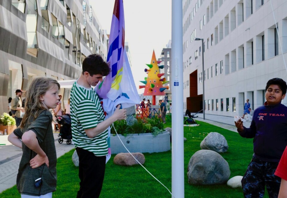 Barna ved Tøyen Biblio heiser et av flaggene som skal vaie i vinden over den nye parken. Foto: Emilie Pascale