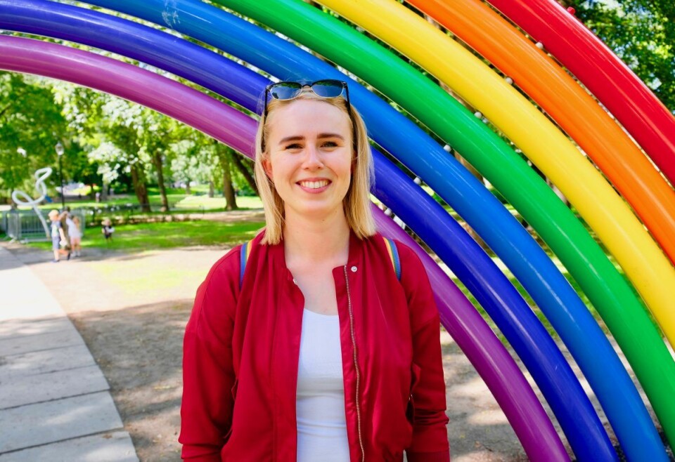 En smilende Fanny Sandberg Vik under regnbuefiguren i Slottsparken. Foto: Emilie Pascale