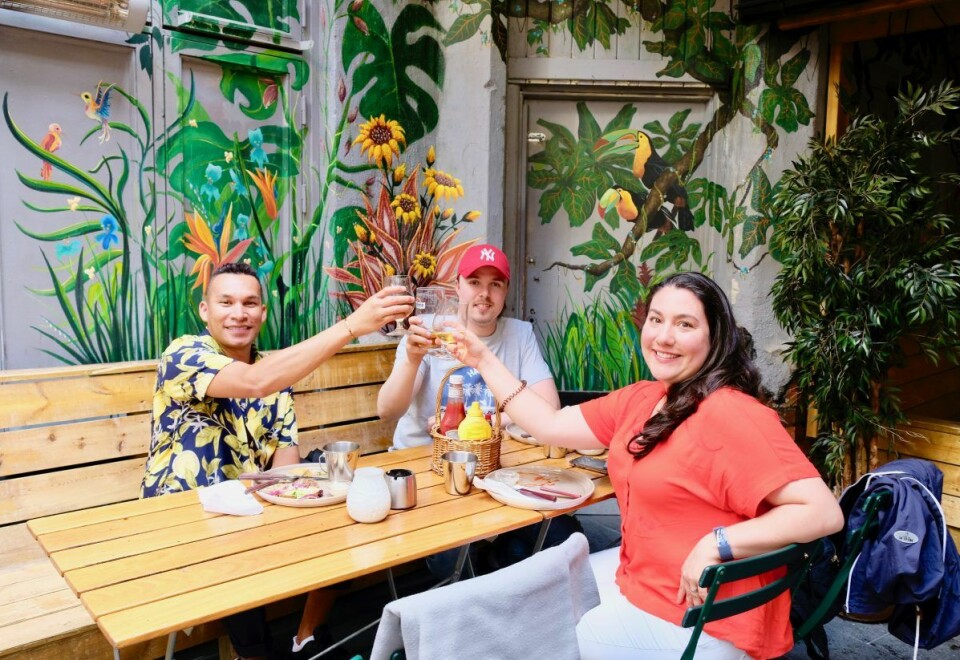 Café Sara har en innvendig bakgård med pent dekorerte vegger, noe disse tre vennene gladelig skåler over. Foto: Emilie Pascale