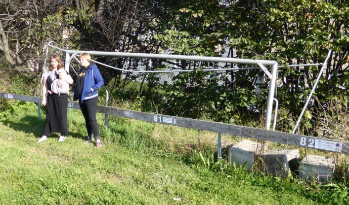 Line Flo (med barn) og Marte Vike Arnesen ved den tidligere fotballbanen med gammelt fotballmål i bakgrunnen. Foto: Åsmund Berge Line Flo (med barn) og Marte Vike Arnesen ved den tidligere fotballbanen med gammelt fotballmål i bakgrunnen. Foto: Åsmund Berge