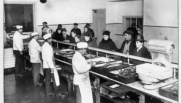 Spanskesyken spredde seg via offentlige møtesteder, som i butikklokaler. Foto fra det kommunale fiskeutsalget på Grønland i 1918.