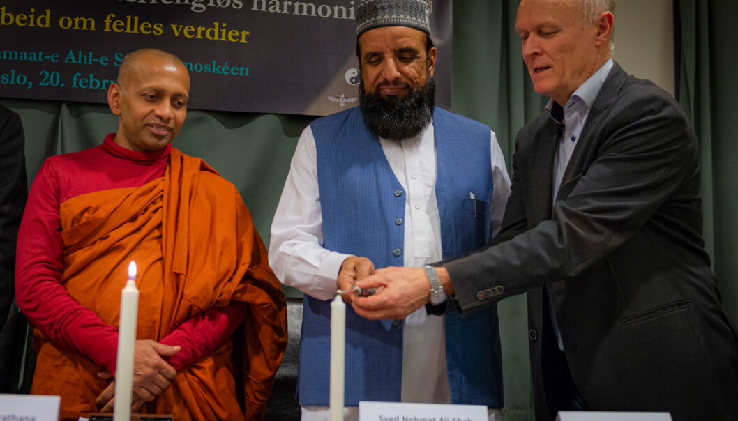 Hovedmunk Bhante Manirathana, imam Syed Nehmat Ali Shah Bukhari og Steinar Murud, fra Fredsforbundet tenner lys som skaper håp.