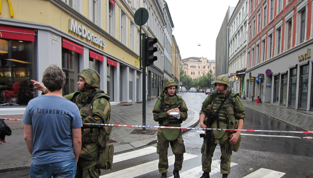 Dagen etter terrorangrepet, 23. juli 2011, der hvor Pløens gate møter Storgata. Soldater ble utplassert i Oslos gater for første gang siden 2. verdenskrig etter angrepet. Den knuste urskiven i Møllergata 19 ved Youngstorget skimtes i bakgrunnen. Butikker så langt unna som Gunerius fikk rutene knust på grunn av trykkbølgene fra eksplosjonen i regjeringskvartalet. Dagen etter terrorangrepet, 23. juli 2011, der hvor Pløens gate møter Storgata. Soldater ble utplassert i Oslos gater for første gang siden 2. verdenskrig etter angrepet. Den knuste urskiven i Møllergata 19 ved Youngstorget skimtes i bakgrunnen. Butikker så langt unna som Gunerius fikk rutene knust på grunn av trykkbølgene fra eksplosjonen i regjeringskvartalet.