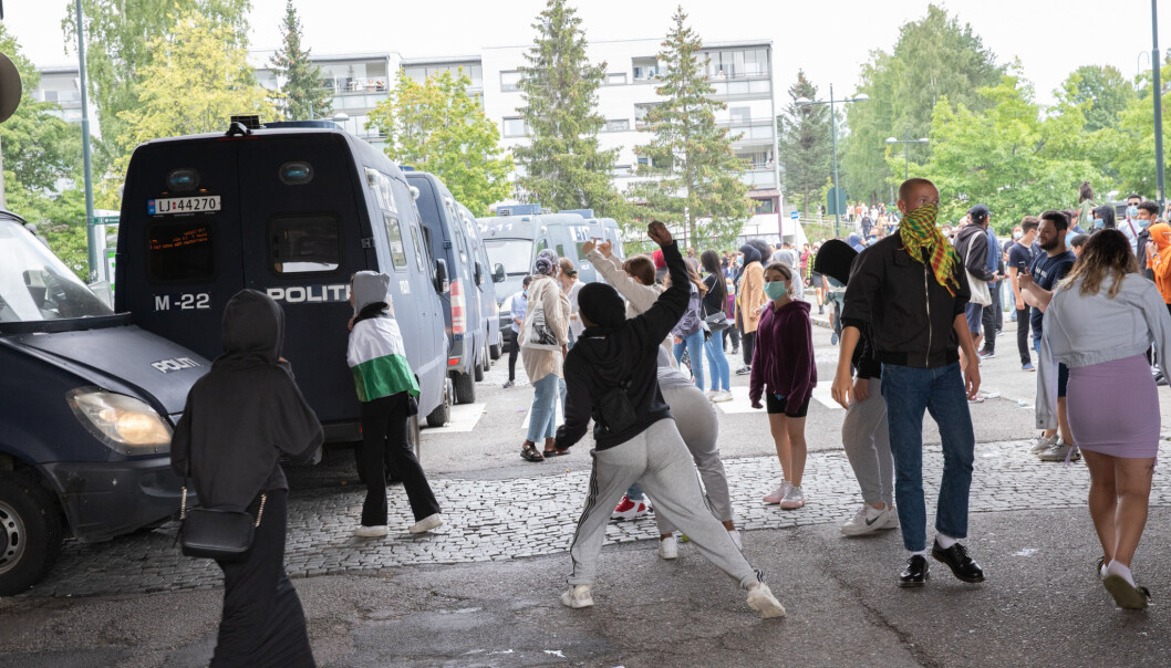 Politiet satte opp en mur av biler for å beskytte Sian. Samtidig ble steinkastende motdemonstranter sprayet med tåregass. Politiet satte opp en mur av biler for å beskytte Sian. Samtidig ble steinkastende motdemonstranter sprayet med tåregass.
