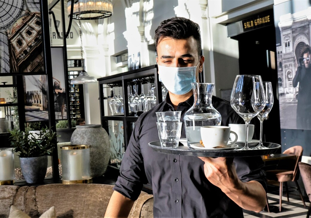 Servitør Firas Aljabli på Olivia restaurant bruker munnbind når han serverer. Fra forrige uke ble det påbudt med munnbind for kelnere og servitører i Oslo.