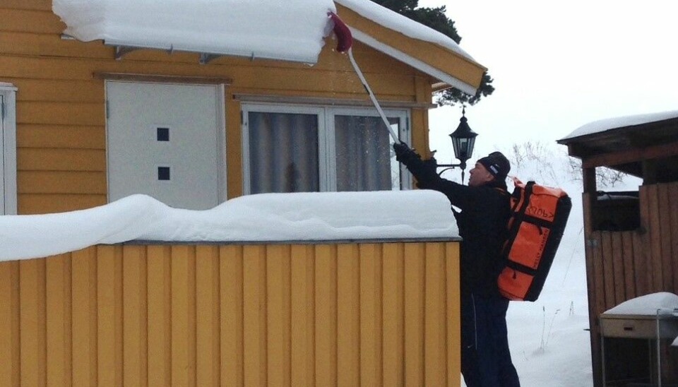 En hytteeier på Lindøya måker snø av taket. Men tyngre arbeid som riving er umulig vinterstid, mener Lindøya Vel og er oppgitt over det de mener er rigide frister fra Oslo kommune.