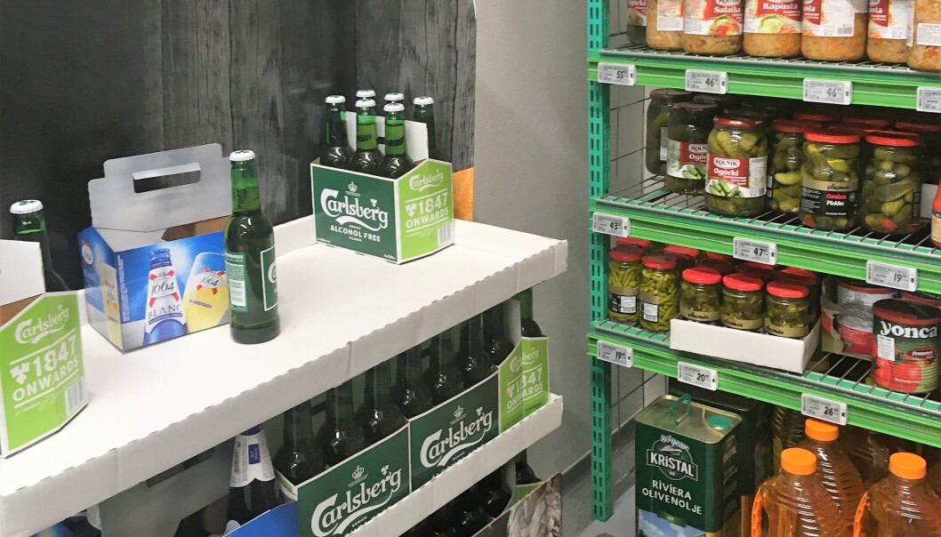På hylla, ved olivenolje og sylteagurker står noen lunkne flasker med lettøl. I den lokale Kiwi-butikken i Møllergata. På hylla, ved olivenolje og sylteagurker står noen lunkne flasker med lettøl. I den lokale Kiwi-butikken i Møllergata.