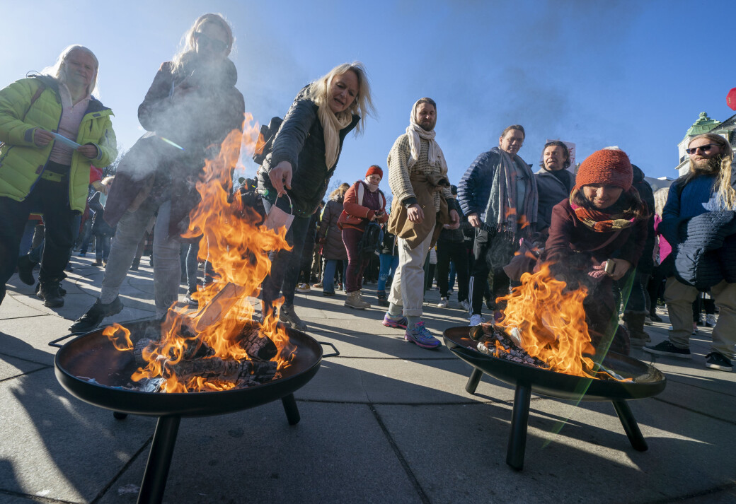 Koronaskeptikere brenner munnbind under en demonstasjon foran Stortinget lørdag ettermiddag. Koronaskeptikere brenner munnbind under en demonstasjon foran Stortinget lørdag ettermiddag.